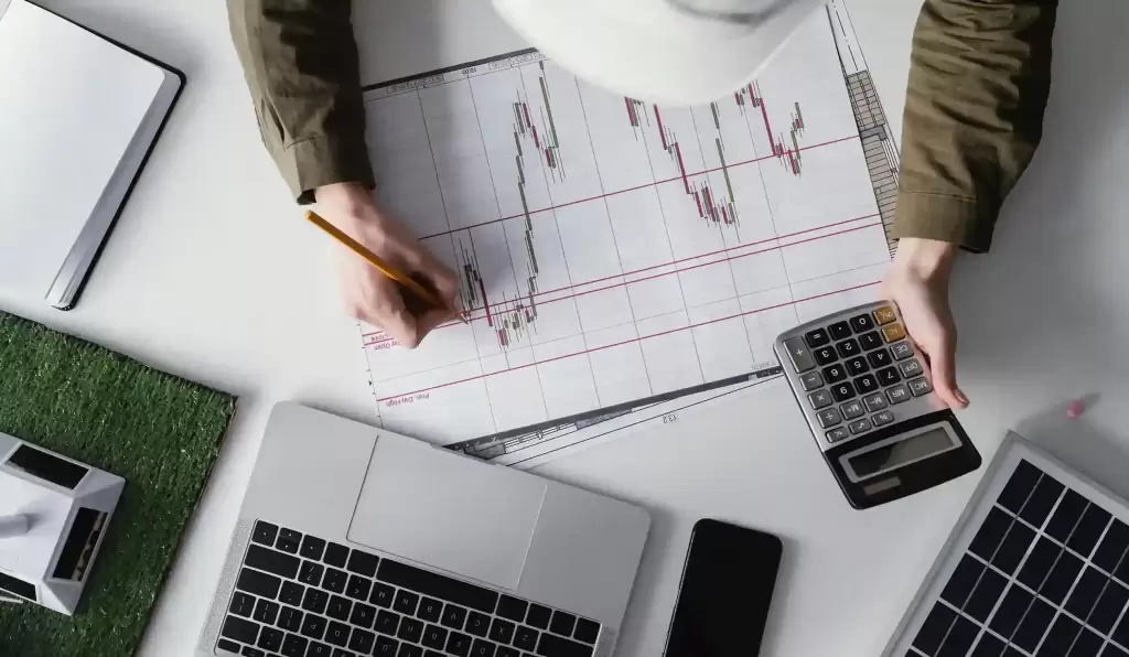 Mano analizando gráficos bursátiles sobre cómo tributa la venta de acciones en España