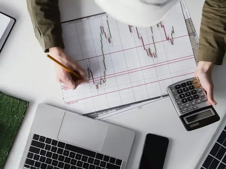 Mano analizando gráficos bursátiles sobre cómo tributa la venta de acciones en España