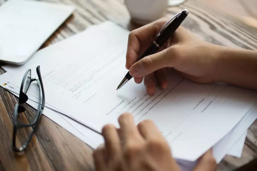 Person signing Form 720 Spain document at a desk