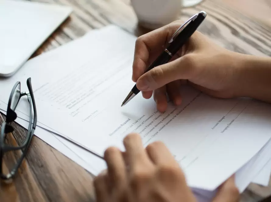 Person signing Form 720 Spain document at a desk