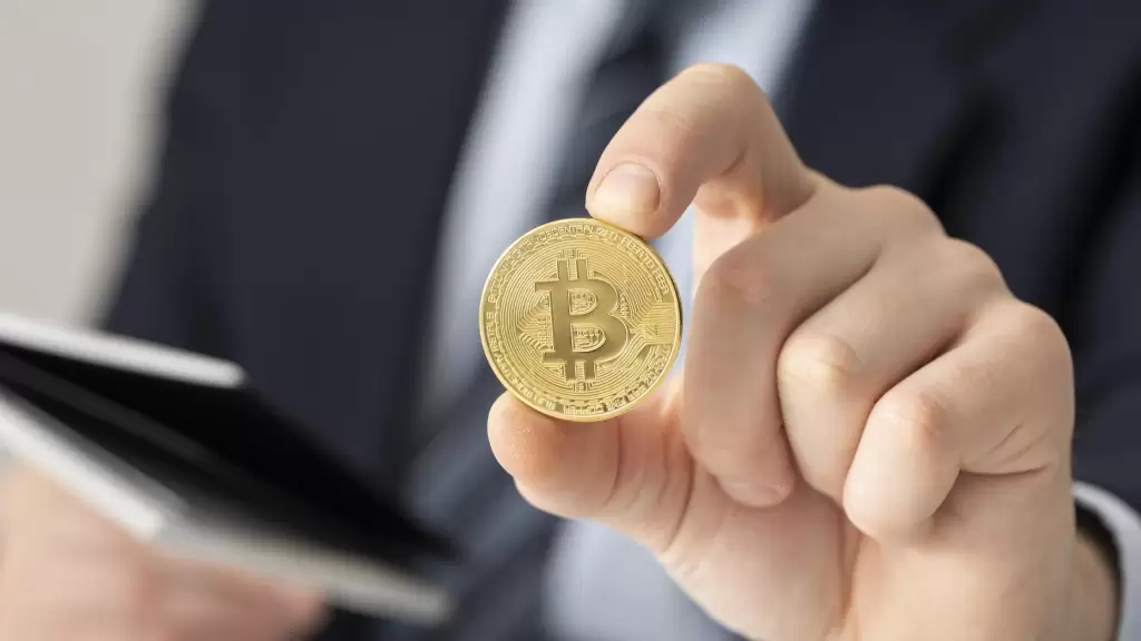 Businessman holding a Bitcoin coin, representing the growing need for crypto tax guidance and financial advice