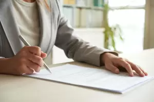A professional signing the necessary legal documentation for terminating an indefinite contract in Spain