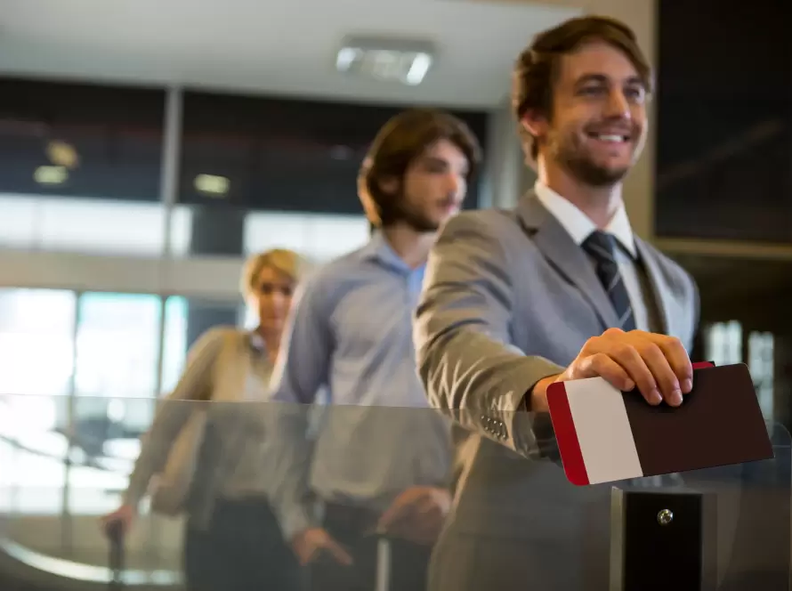 A smiling business professional going through airport security, holding their passport. The image symbolizes the arrival in Spain of an "impatriate" under the Beckham Law.