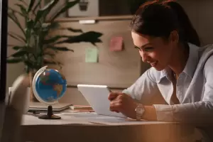 What Is International Taxation & How Can a Tax Lawyer Help You? 1 Young entrepreneur or investor using a tablet for a digital meeting, with a globe nearby, symbolizing international taxation planning and global compliance.