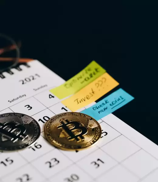 crypto-tax-consulting-Benavides-Asociados (2) Physical Bitcoin coins on a calendar with sticky notes, symbolizing tax planning deadlines and the importance of expert crypto tax advice for digital assets.