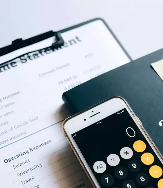 llevanza-de-la-contabilidad-Benavides-asociados (2) Informe de ingresos (Income Statement) junto a un smartphone con calculadora y una nota de "Call Tax Agent", representando la gestión contable y la necesidad de asesoría fiscal.